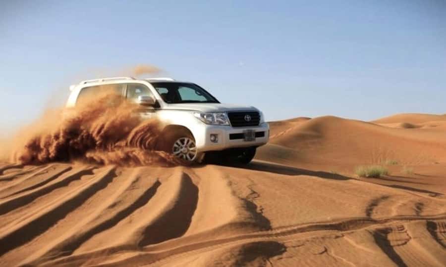 Doha Desert Safari: Sandboarding, Camel Ride & Swimming Fun - Dune bashing across the golden sand